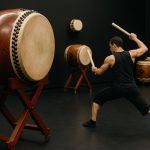 Taiko drummers practicing synchronized group routines for performance tour preparation