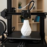 Close-up of a modern 3D printer creating a plastic model on a home desk